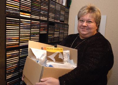 Sylvia mit Karton vor CD-Regal